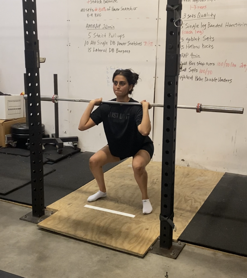 Female front squatting with barbell to improve strength